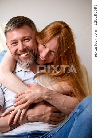 Smiling couple affectionately embracing while enjoying a happy moment together Smiling couple affectionately embracing while enjoying a happy moment together 129190099