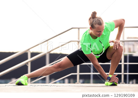 Woman stretching outdoors in activewear during a workout session 129190109