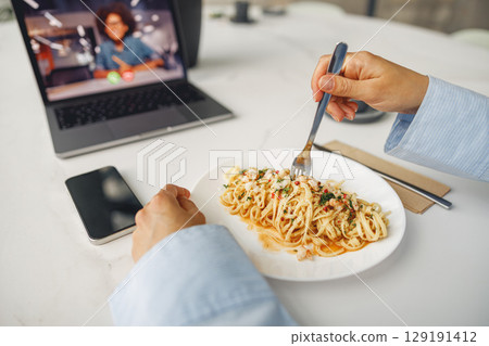 Relishing a meal while simultaneously indulging in online content is a delightful experience Relishing a meal while simultaneously indulging in online content is a delightful experience 129191412