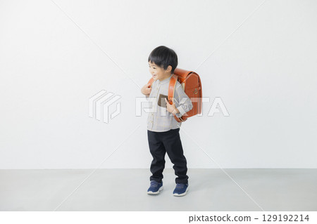 Elementary school student carrying a school bag 129192214
