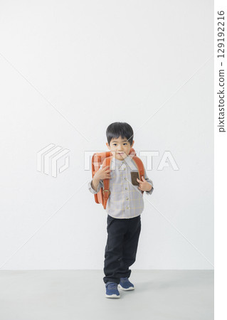 Elementary school student carrying a school bag Elementary school student carrying a school bag 129192216