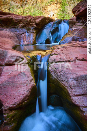 Cascading Waterfall and Red Rocks Motion at Kanarra Falls Low Angle View 129192262