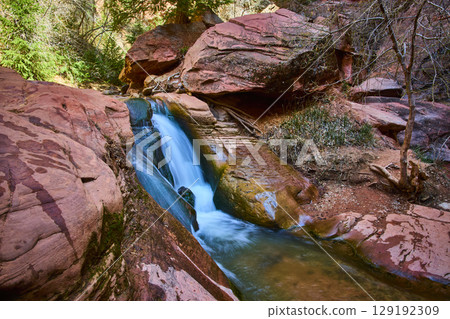 Waterfall Motion Over Red Sandstone Rocks in Canyon Eye Level View 129192309