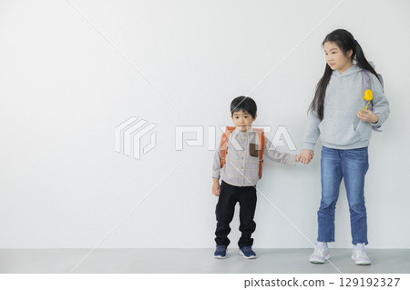 Elementary school student carrying a school bag 129192327