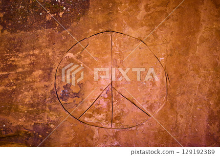 Peace Symbol Carved in Red Rock Texture Southwest Nature Eye Level View 129192389