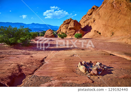 Red Sandstone Formations with Desert Fire Ring and Shrubs Eye Level Perspective 129192440