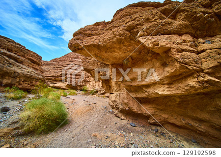 Rugged Red Rock Formations in Desert Sunlit Pathway Perspective Rugged Red Rock Formations in Desert Sunlit Pathway Perspective 129192598