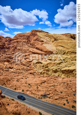 Aerial of SUV on Road Through Vibrant Valley of Fire Desert Landscape 129192655