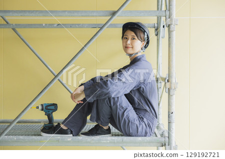 Young female worker working at a construction site Young female worker working at a construction site 129192721
