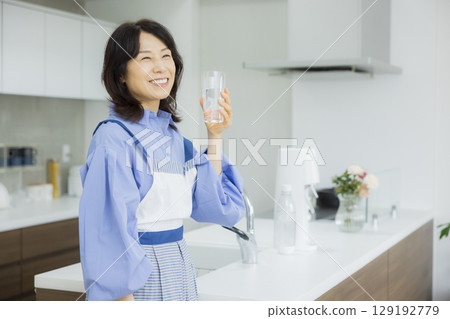 一個女人在廚房喝水 129192779