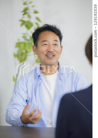 Middle-aged man having a meeting in the office Middle-aged man having a meeting in the office 129192839