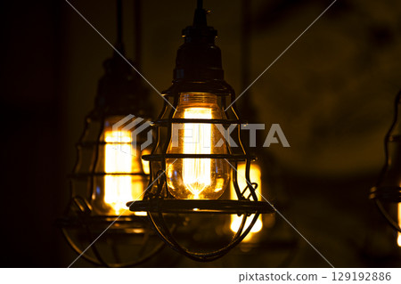 Warm glow of old-fashioned tungsten light bulb Warm glow of old-fashioned tungsten light bulb 129192886