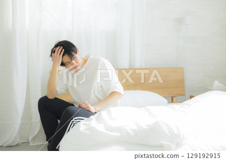 坐在床上的一個年輕人 129192915