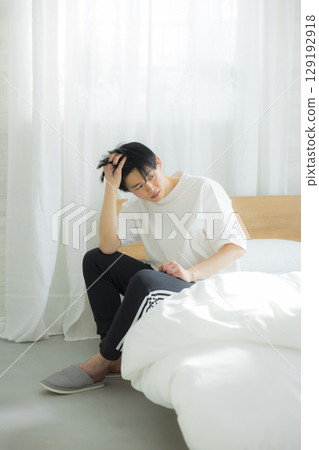 A young man sitting in bed A young man sitting in bed 129192918
