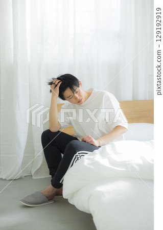 A young man sitting in bed A young man sitting in bed 129192919