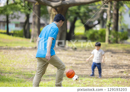 Children and men in polo shirts playing in the park 129193203