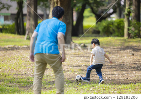 Children and men in polo shirts playing in the park 129193206