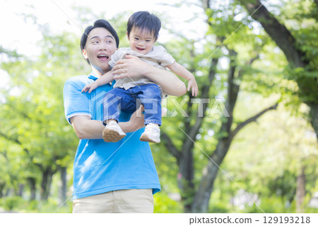 穿著 Polo 衫的孩子和男人在公園裡玩耍 穿著 Polo 衫的孩子和男人在公園裡玩耍 129193218