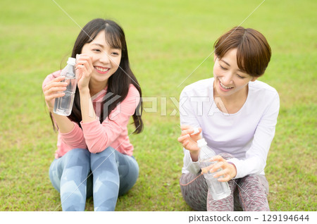 兩位女士在運動後休息並補充水分 兩位女士在運動後休息並補充水分 129194644