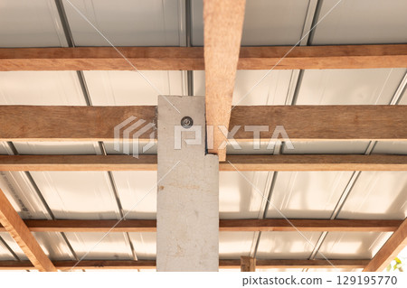 Roof under construction with metal sheet and wood structure. Roof under construction with metal sheet and wood structure. 129195770