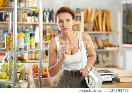Adult woman choosing groceries in store Adult woman choosing groceries in store 129195792