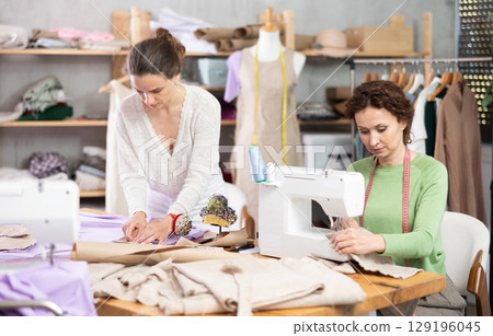 Two female tailors creating custom garments in workshop Two female tailors creating custom garments in workshop 129196045