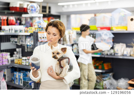 Woman selecting dry dog food for Yorkie in pet store Woman selecting dry dog food for Yorkie in pet store 129196056