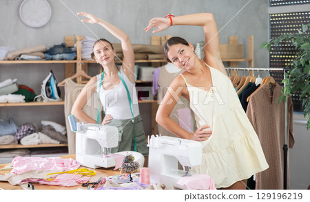Two young women tailor does limbering-up 129196219