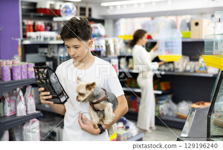 Preteen boy selecting dry dog food for Yorkie in pet store Preteen boy selecting dry dog food for Yorkie in pet store 129196240