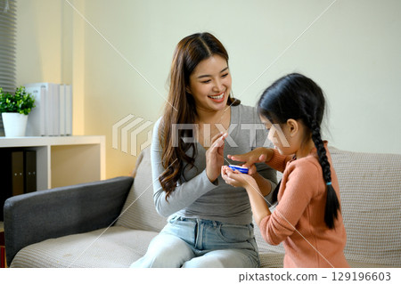 Happy mother and her daughter enjoying a fun skincare routine at home Happy mother and her daughter enjoying a fun skincare routine at home 129196603