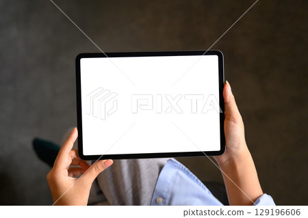Close up of hands holding a digital tablet with blank screen, for mockup or design presentation Close up of hands holding a digital tablet with blank screen, for mockup or design presentation 129196606