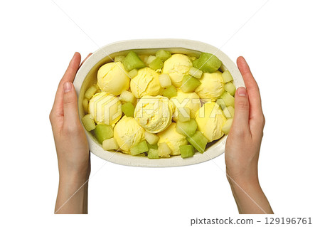 Hands hold a bowl of yellow ice cream and melon, isolated on white, PNG 129196761