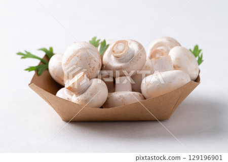 White Button mushroom or Champignon mushroom (Agaricus bisporus) in paper bowl, Food ingredient White Button mushroom or Champignon mushroom (Agaricus bisporus) in paper bowl, Food ingredient 129196901
