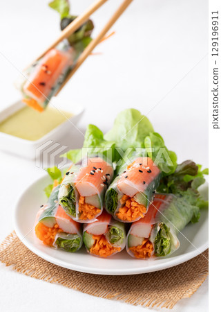 Salad roll with crab stick, carrot, cucumber and lettuce wrapped with rice paper and dipping sauce Salad roll with crab stick, carrot, cucumber and lettuce wrapped with rice paper and dipping sauce 129196911