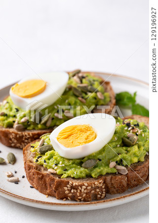 Avocado toast with boiled egg, sunflower seeds, pumpkin seeds and sesame seeds, Healthy eating 129196927
