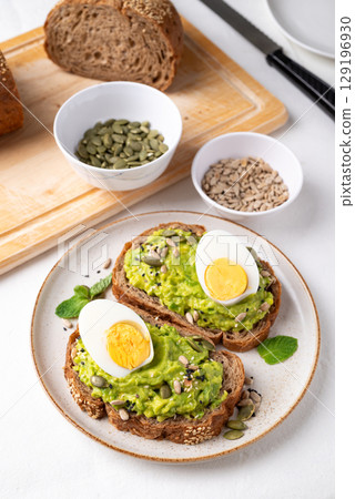 Avocado toast with boiled egg, sunflower seeds, pumpkin seeds and sesame seeds, Healthy eating Avocado toast with boiled egg, sunflower seeds, pumpkin seeds and sesame seeds, Healthy eating 129196930