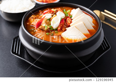 Korean food (Kimchi Jjigae), Kimchi soup with tofu, pork, scallion and chili in Korean stone bowl  129196945