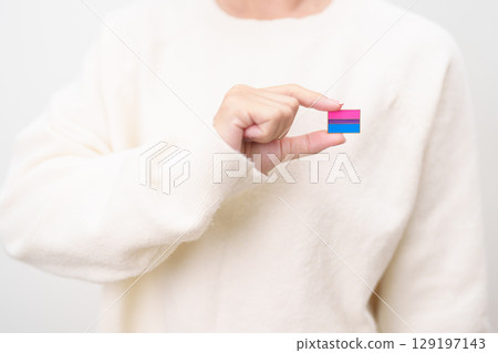 Bisexuality Celebrate Day and LGBT pride month, LGBTQ or LGBTQIA concept. Hand holding purple, pink and blue flag shape for Lesbian, Gay, Bisexual, Transgender, Queer, Pansexual, Marriage Equality Law Bisexuality Celebrate Day and LGBT pride month, LGBTQ or LGBTQIA concept. Hand holding purple, pink and blue flag shape for Lesbian, Gay, Bisexual, Transgender, Queer, Pansexual, Marriage Equality Law 129197143