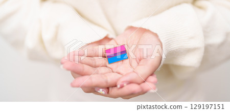 Bisexuality Celebrate Day and LGBT pride month, LGBTQ or LGBTQIA concept. Hand holding purple, pink and blue flag shape for Lesbian, Gay, Bisexual, Transgender, Queer, Pansexual, Marriage Equality Law 129197151