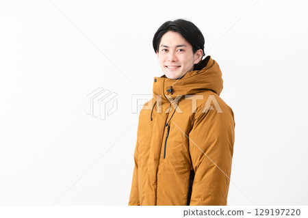 Young man wearing a down coat 129197220