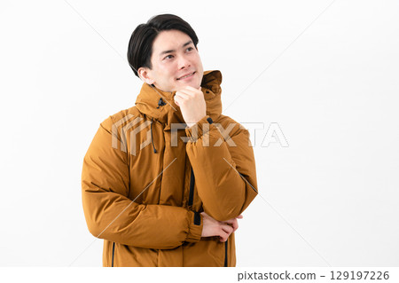 Young man wearing a down coat Young man wearing a down coat 129197226