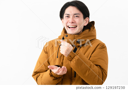 Young man wearing a down coat 129197230