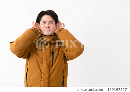 Young man wearing a down coat Young man wearing a down coat 129197257