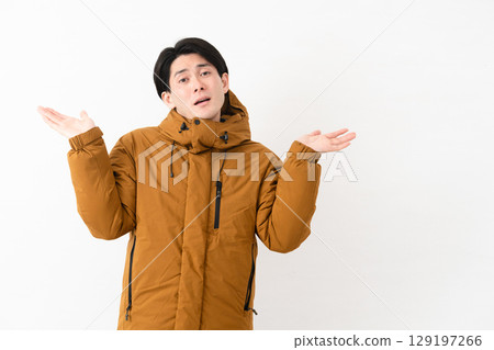 Young man wearing a down coat 129197266