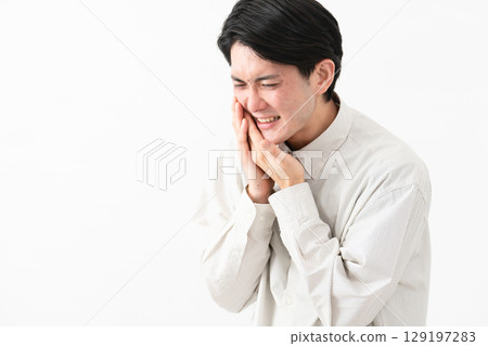 Young man wearing a long-sleeved white shirt Young man wearing a long-sleeved white shirt 129197283