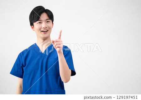 A young man wearing medical scrubs 129197451