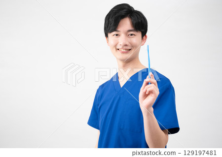 A young man wearing medical scrubs A young man wearing medical scrubs 129197481