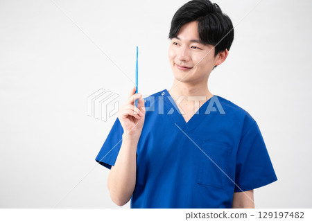 一名身穿醫用手術服的年輕人 一名身穿醫用手術服的年輕人 129197482