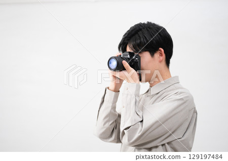 Young man holding a film camera 129197484