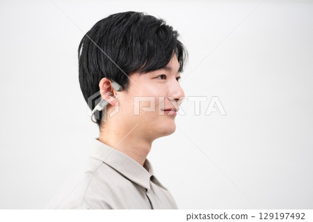 Young man listening to music with wireless earphones Young man listening to music with wireless earphones 129197492